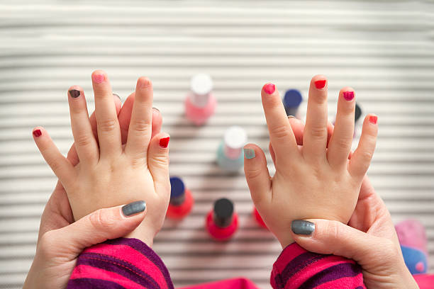Mother and daughter having fun painting fingernails Mother and daughter having fun painting fingernails, family time concept, view from above painting fingernails stock pictures, royalty-free photos & images