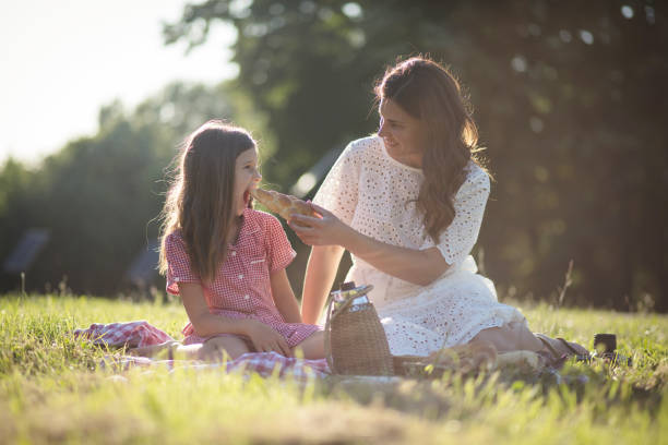 Mother and daughter having picnic together. stock photo