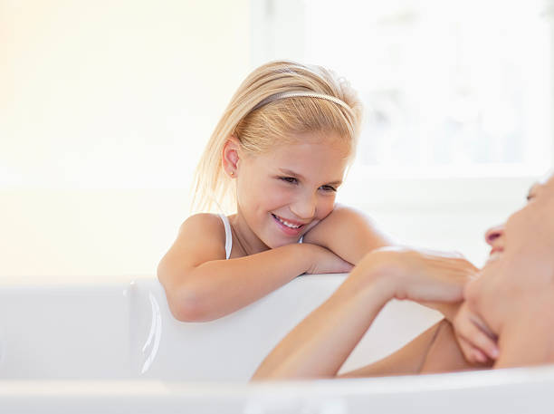 Mother and daughter in bathroom, woman taking bath  tickling beautiful women pictures stock pictures, royalty-free photos & images