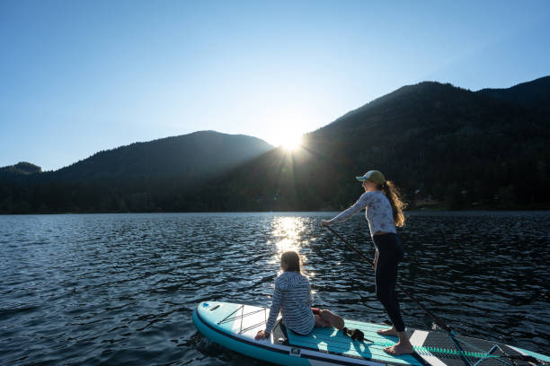 Mother and daughter on a paddle board adventure stock photo