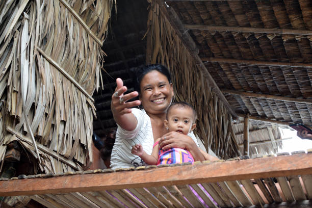 Mother and daughter on balcony of Bajau stilt shanty house Lucena City, Quezon, Philippines - October 11, 2020: Mother and daughter on balcony of Bajau stilt shanty house filipino woman stock pictures, royalty-free photos & images