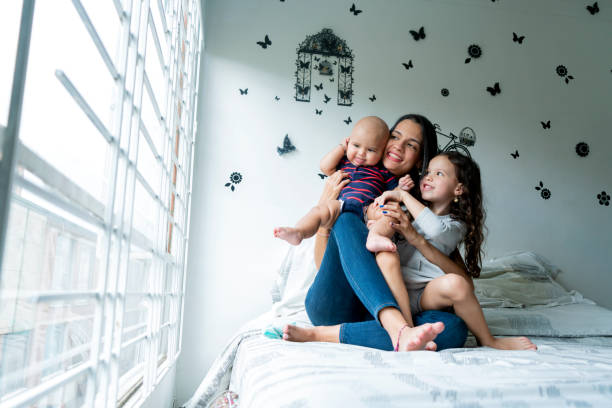 madre e hija jugando con el bebé en la habitación - latin family fotografías e imágenes de stock