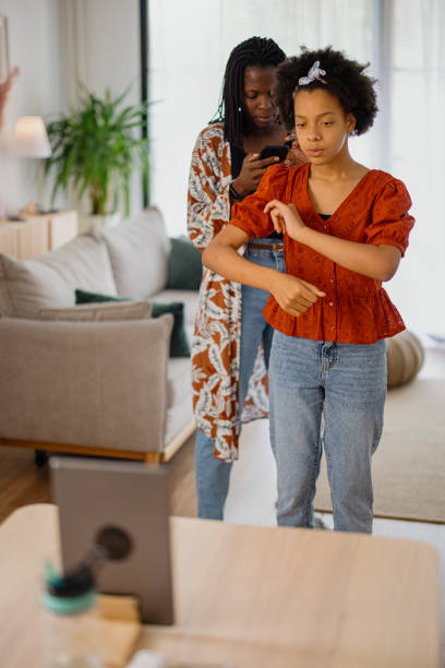 Mother and daughter recording a dance video at home Mom and daughter dancing  and making video at home, tik tok concept tiktok stock pictures, royalty-free photos & images
