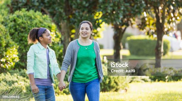 Mother and daughter taking a walk, holding hands