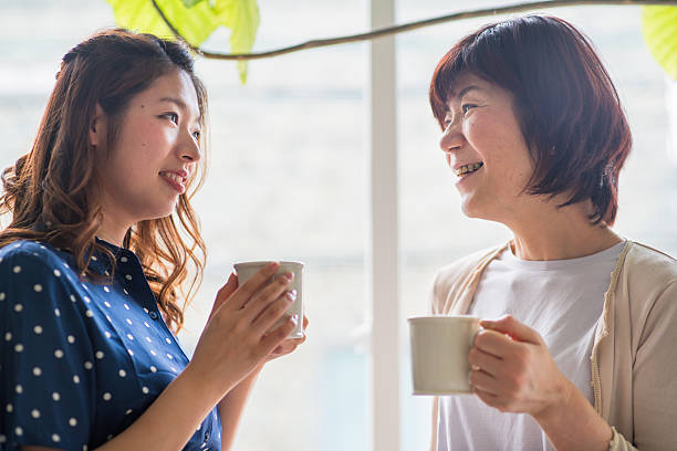 mother and daughter talking Mother and daughter drinking coffee and talking together. Kyoto, Japan. May 2016 asian mother talking with daughter stock pictures, royalty-free photos & images