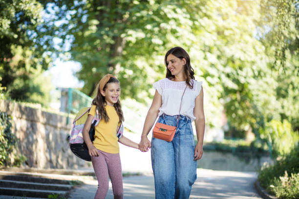 Mother and daughter walking trough nature and holding hands. stock photo