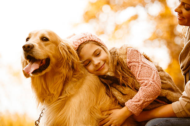 秋の公園で彼らの犬と母と娘 - 犬　少女 ストックフォトと画像