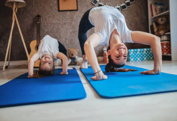 mother and daughter working out together doing exercise at home - yoga crianças imagens e fotografias de stock