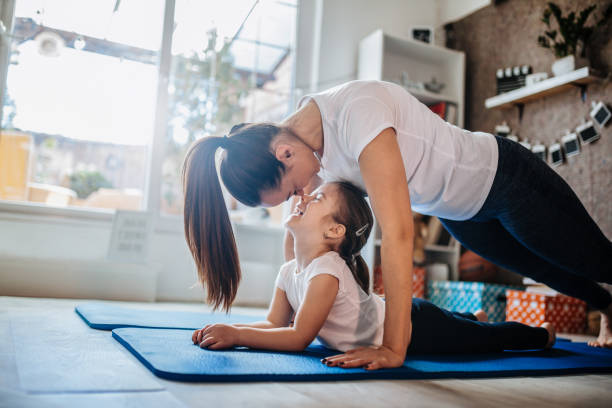 mother and daughter working out together doing exercise at home - yoga crianças imagens e fotografias de stock