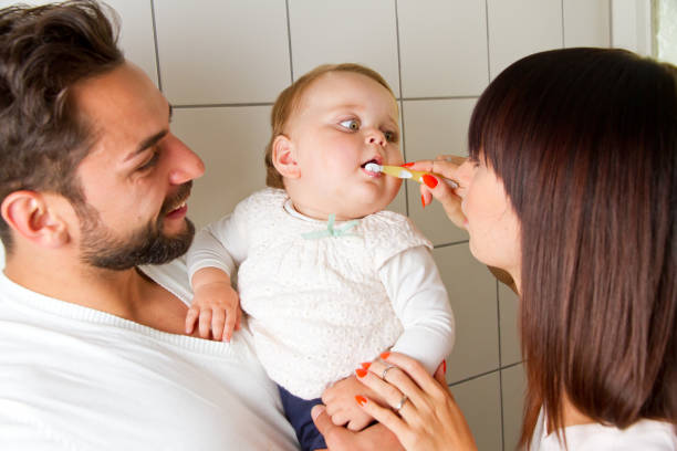 Mother and father brushing teeth of their baby Family in bathroom brushing teeth rotten teeth in children stock pictures, royalty-free photos & images