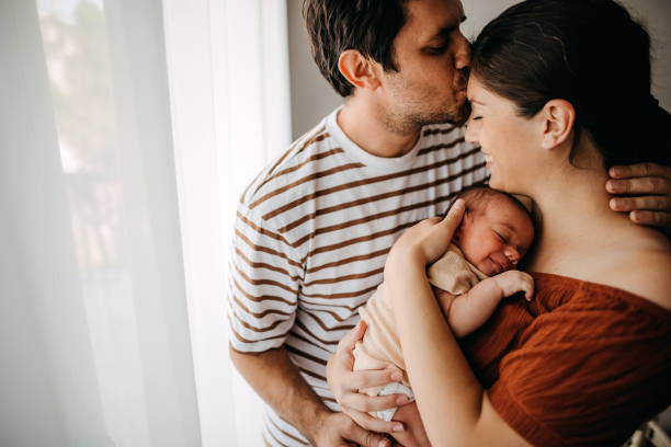 Mother and father taking care of newborn son stock photo