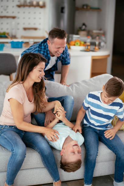 Mother and father tickling son. Mother and father tickling son. Young family enjoying at home. tickling beautiful women pictures stock pictures, royalty-free photos & images