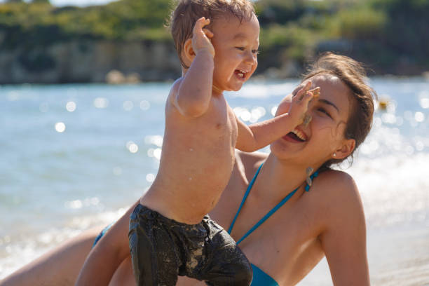A mother and her son are playing on a beach stock photo