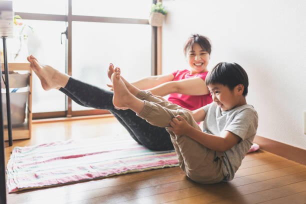 mother and son exercising yoga together at home - yoga crianças imagens e fotografias de stock