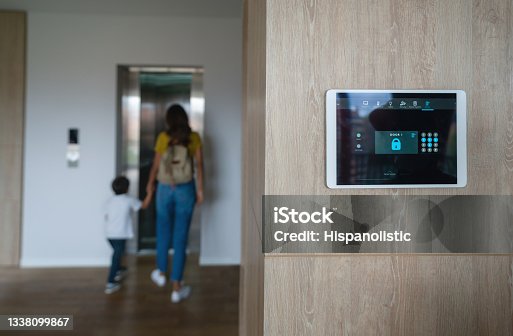 istock Mother and son leaving the house and locking the door using an automated security system 1338099867