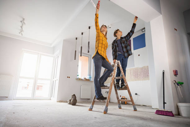 A couple taking measurements of their ceiling after combining two rooms
