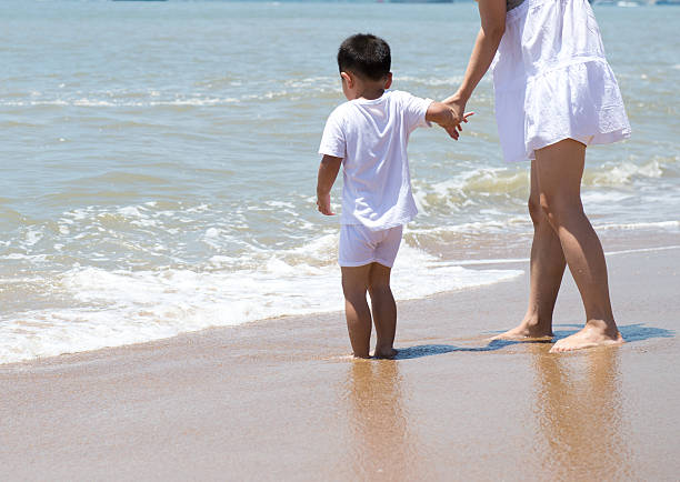 Mother and son Mother and son walking on beach divorce beach stock pictures, royalty-free photos & images