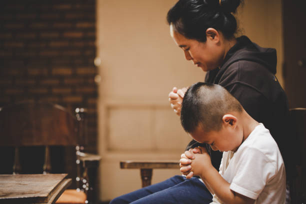 Mother and son praying and praising God stock photo