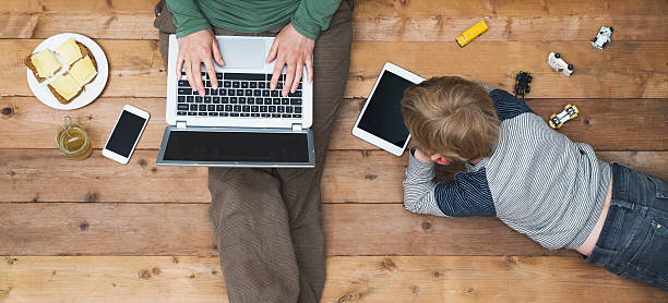 Mother and son using tablet and laptop top view of mother and son using digital media. Modern online generation addicted to internet. electrical equipment photos stock pictures, royalty-free photos & images