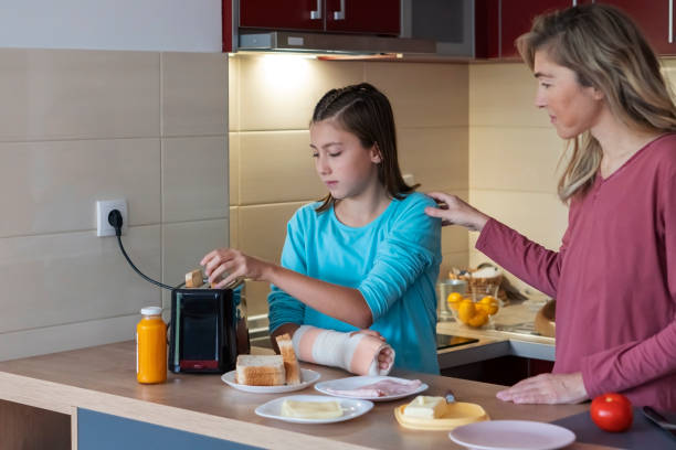 Mother and teenage daughter in the kitchen stock photo