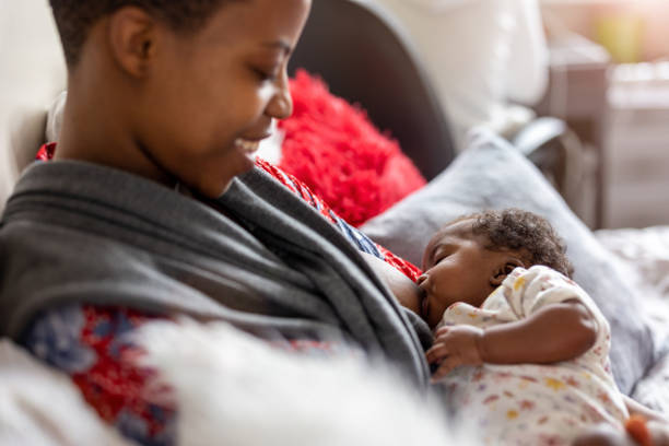 mother breastfeeding baby at home - breastfeeding stockfoto's en -beelden