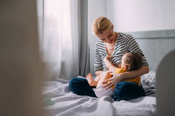Mother Breastfeeding her Baby at Home stock photo