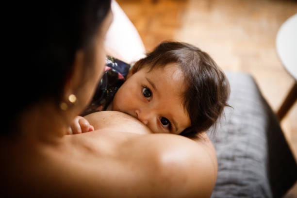 moeder die haar baby borstvoeding geeft - breastfeeding stockfoto's en -beelden