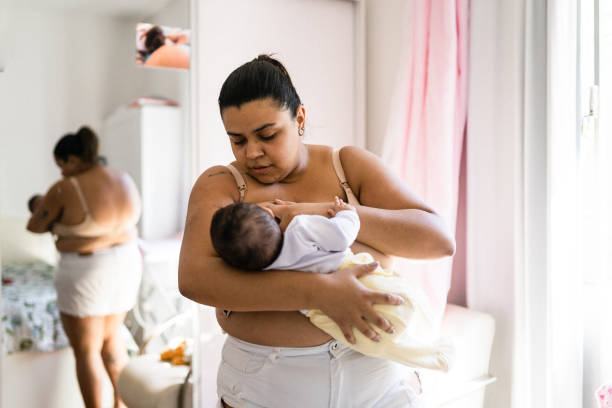 mother breastfeeding in the bedroom stock photo