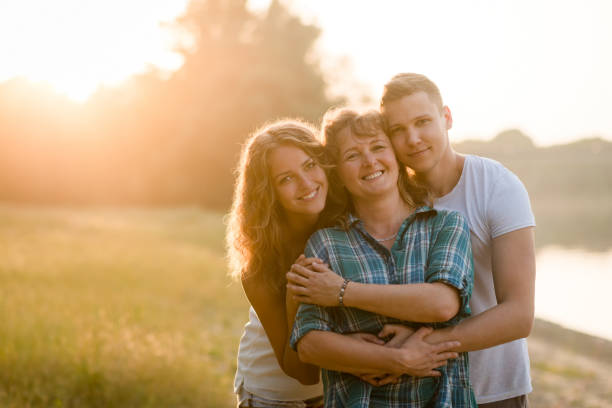 Mother, daughter and son posing together. Family bonding. Young kids with their loving mother on nature background mother and teenage son stock pictures, royalty-free photos & images