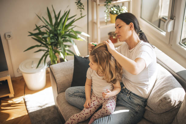 Mother doing head lice cleaning on daughter stock photo