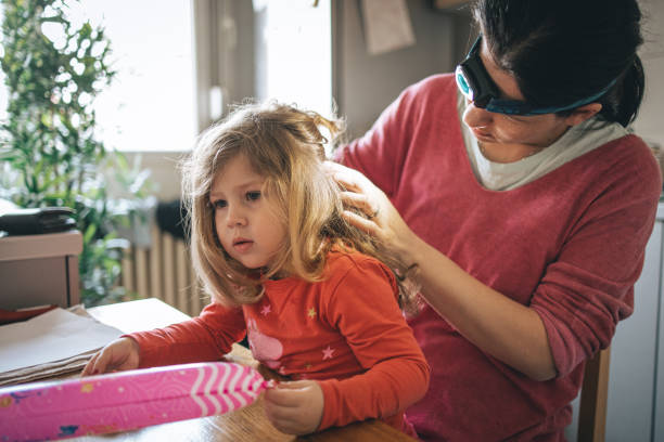 Mother doing head lice Inspection on daughter stock photo