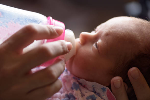 Mother feeds the newborn with bottle milk Mother feeds the newborn with bottle milk baby formula stock pictures, royalty-free photos & images