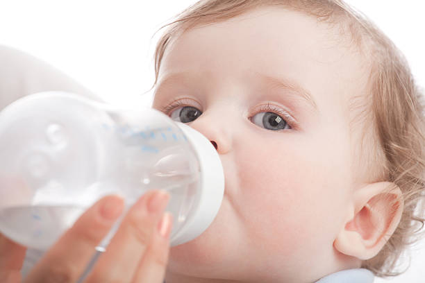 Mother give drink her son by feeding bottle stock photo