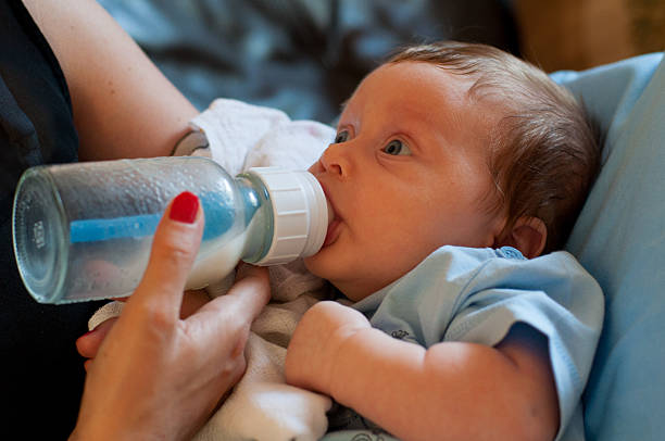 Mother gives milk to newborn stock photo