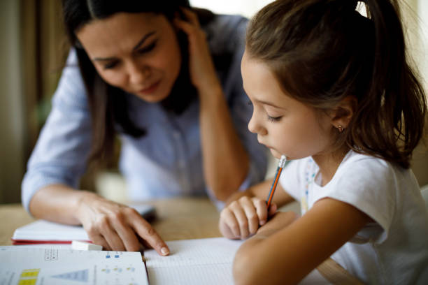 Mother helping daughter with homework  homework stock pictures, royalty-free photos & images