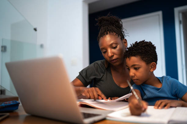 moeder die zoon met thuiswerk helpt - huiswerk stockfoto's en -beelden