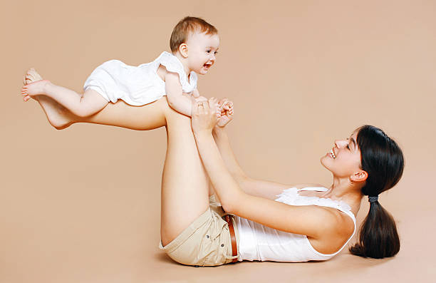 Mother holding baby, fun, exercise, leisure - concept stock photo