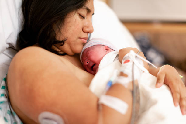 Mother Holding Brand New Baby In Hospital Delivery Room stock photo
