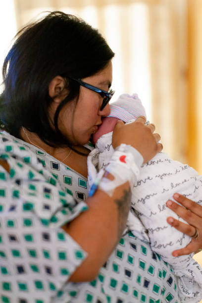 Mother Holding Brand New Baby In Hospital Delivery Room stock photo
