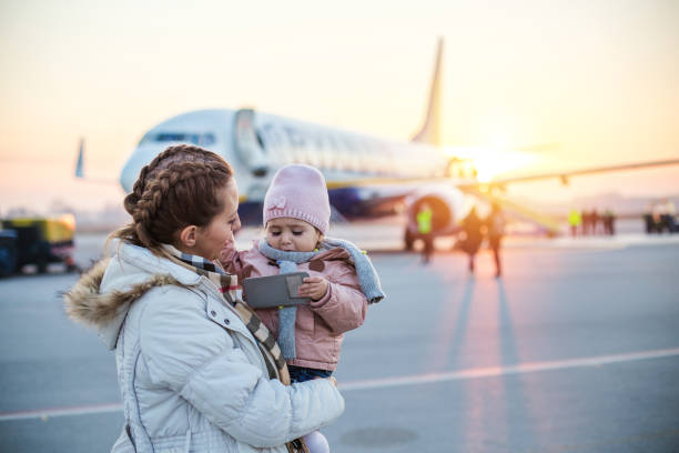 Mother holding daughter at the airport stock photo
