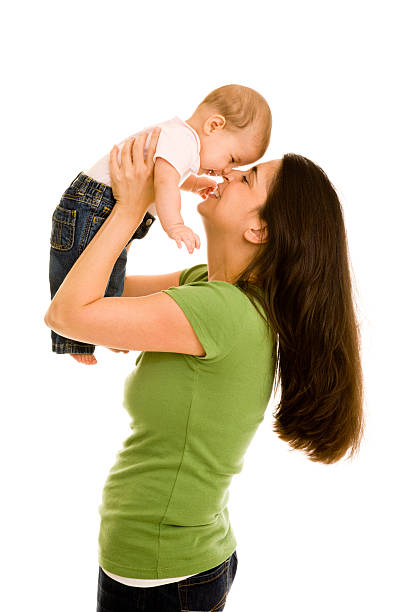 Mother holding daughter in air tapping her nose stock photo
