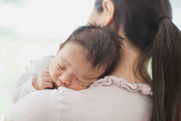 Mother holding sleepy newborn stock photo