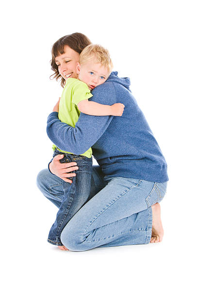 Mother hugging blond young boy on white background stock photo