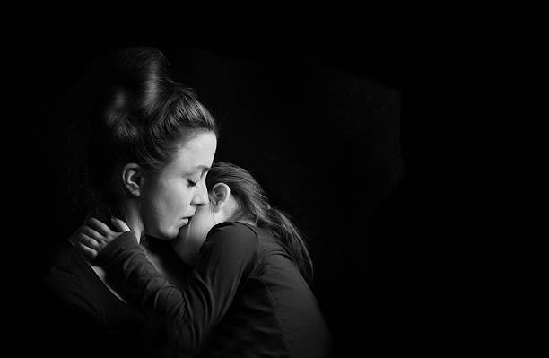 Mother Hugging Daughter Tenderly stock photo