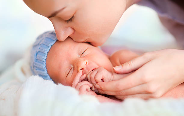 Mother kissing baby stock photo