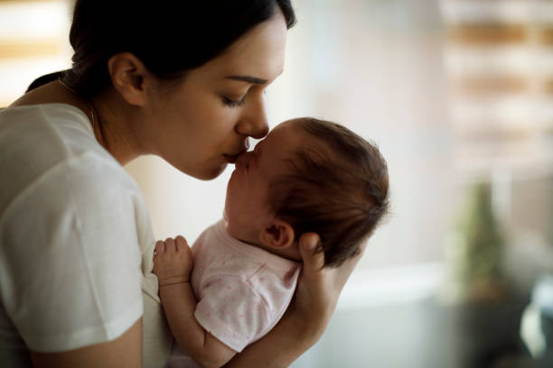 Mother kissing her crying baby Mother kissing her crying baby  soothe crying baby stock pictures, royalty-free photos & images