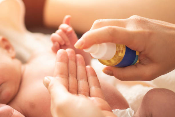Mother makes massage with baby oil Mother makes massage with baby oil babys skin care stock pictures, royalty-free photos & images