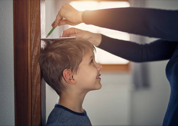 Mother measuring son's height Mother measuring son's height and marking it with pencil on door.
Nikon D810 high up stock pictures, royalty-free photos & images