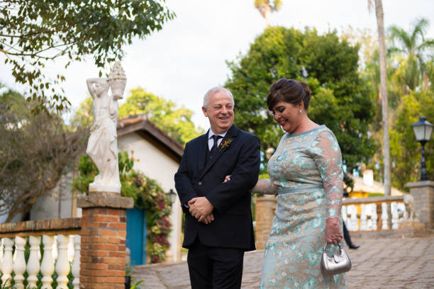 Mother of the Bride and Father of the Groom entering at wedding ceremony Mother of the Bride and Father of the Groom entering at wedding ceremony mother of the bride dress stock pictures, royalty-free photos & images