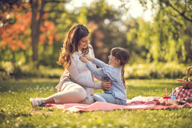 Mother playing with daughter in nature Mother enjoying picnic with daughter in nature tickling beautiful women pictures stock pictures, royalty-free photos & images